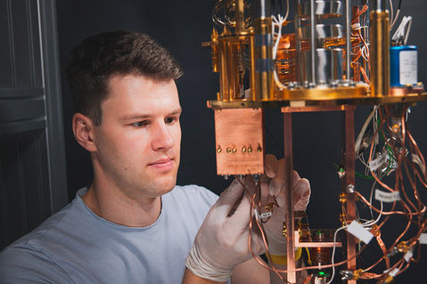 Kilian Kessler fotografierte am Physik Departement ETH Zürich Forschung in einem Labor des Instituts für Festkörperphysik. Zu sehen sind Personen die an einem Kryostat arbeiten.