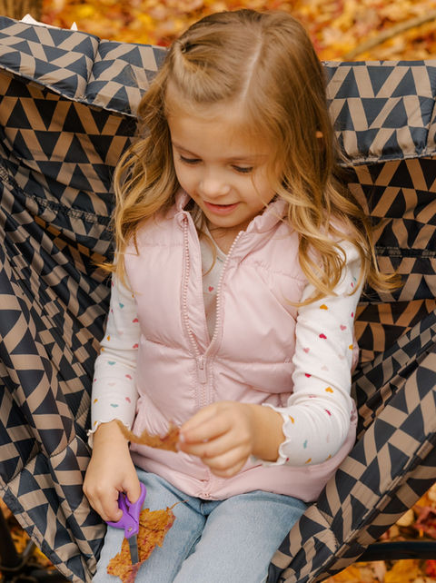 Child practicing cutting with scissors during pediatric OT fine-motor activity.