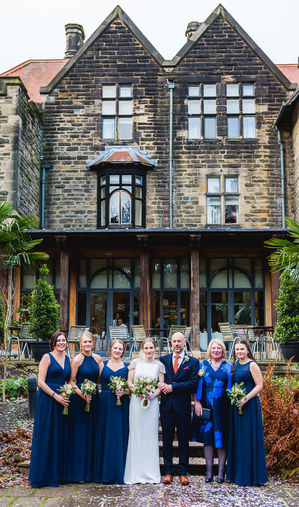 Jesmond Dene House wedding, Newcastle Upon Tyne. a group of people posing for a picture in front of a building