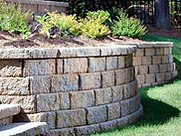 Tiered retaining wall with built-in planters and modern LED uplighting for a visually stunning outdoor design.