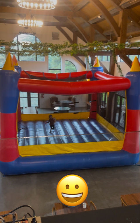 A massive 20x20 inflatable bounce house with vibrant colors, set up outdoors for a kids’ party, featuring a spacious jumping area.
