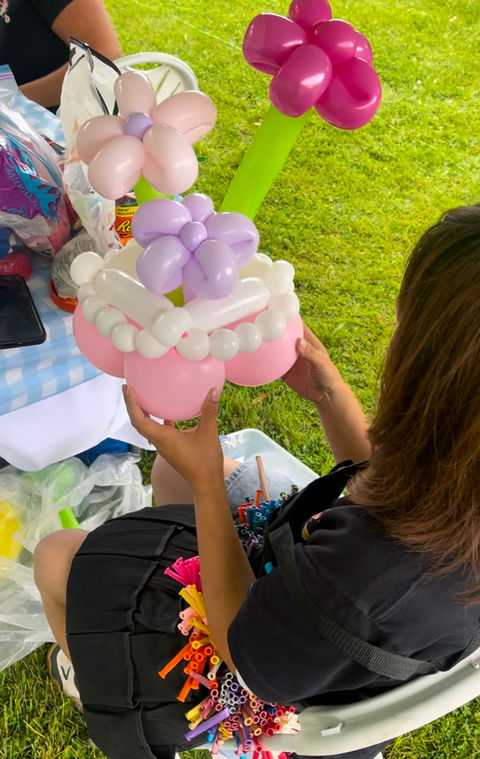 A delicate balloon flower arrangement with vibrant petals, twisted stems, and a decorative basket, showcasing expert balloon artistry.