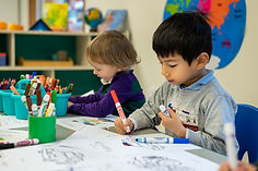 Two Preschool students are coloring during a free time in French class