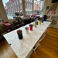 Craft activity table with multiple frame outlines and colorful art supplies.