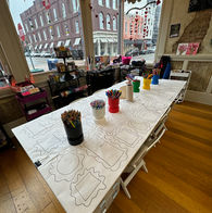 Craft activity table with multiple frame outlines and colorful art supplies.