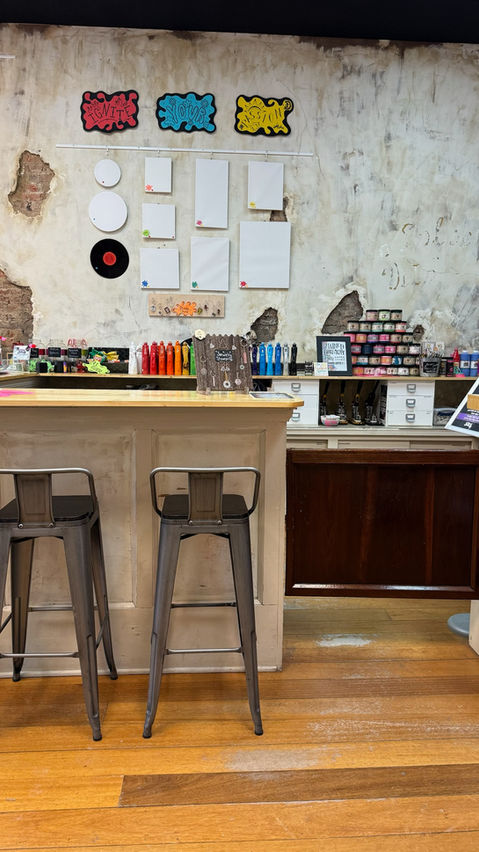 Craft studio counter with bar stools and various art supplies.
