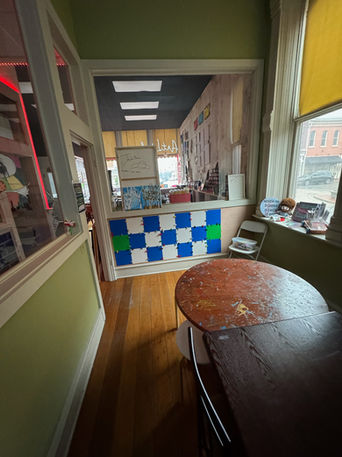 Small reception area with blue-green checkered counter and wooden table.