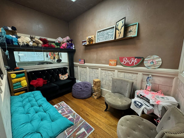 Comfortable craft lounge with yarn, cushions, "BIE HE" and "HOME" decor.