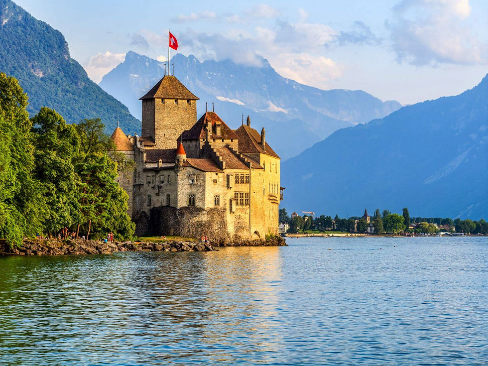 The medieval Chillon Castle on the shore of Lake Geneva with the Alps in the background