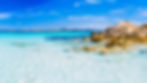 The stunning turquoise and crystalline waters of a beautiful beach in Sardinia, inviting travelers to visit