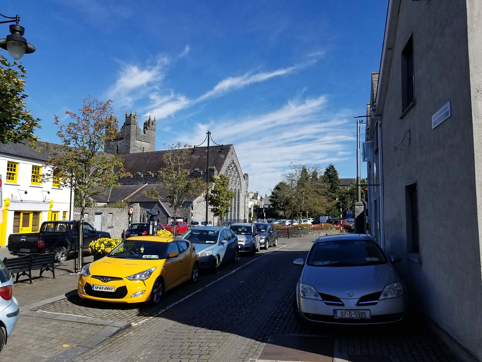 trânsito e carros estacionados em rua estreita em Kilkenny, na Irlanda, mão inglesa