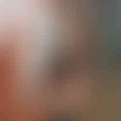 Woman balances on scaffolding in order to paint part of a mural on a wall