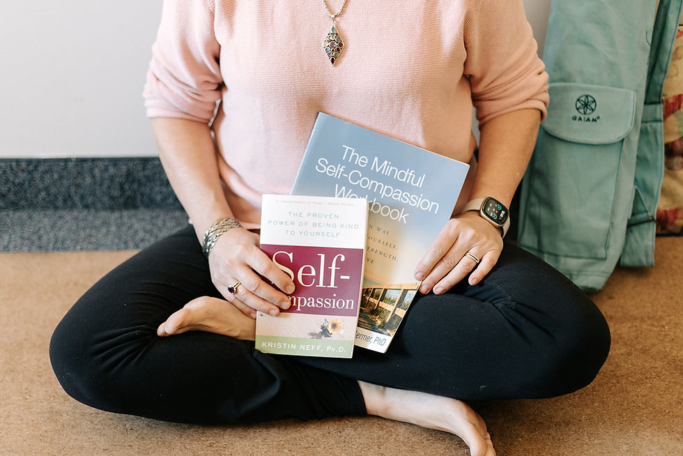 LisaClendening in a yoga form holding self compassion therapy book