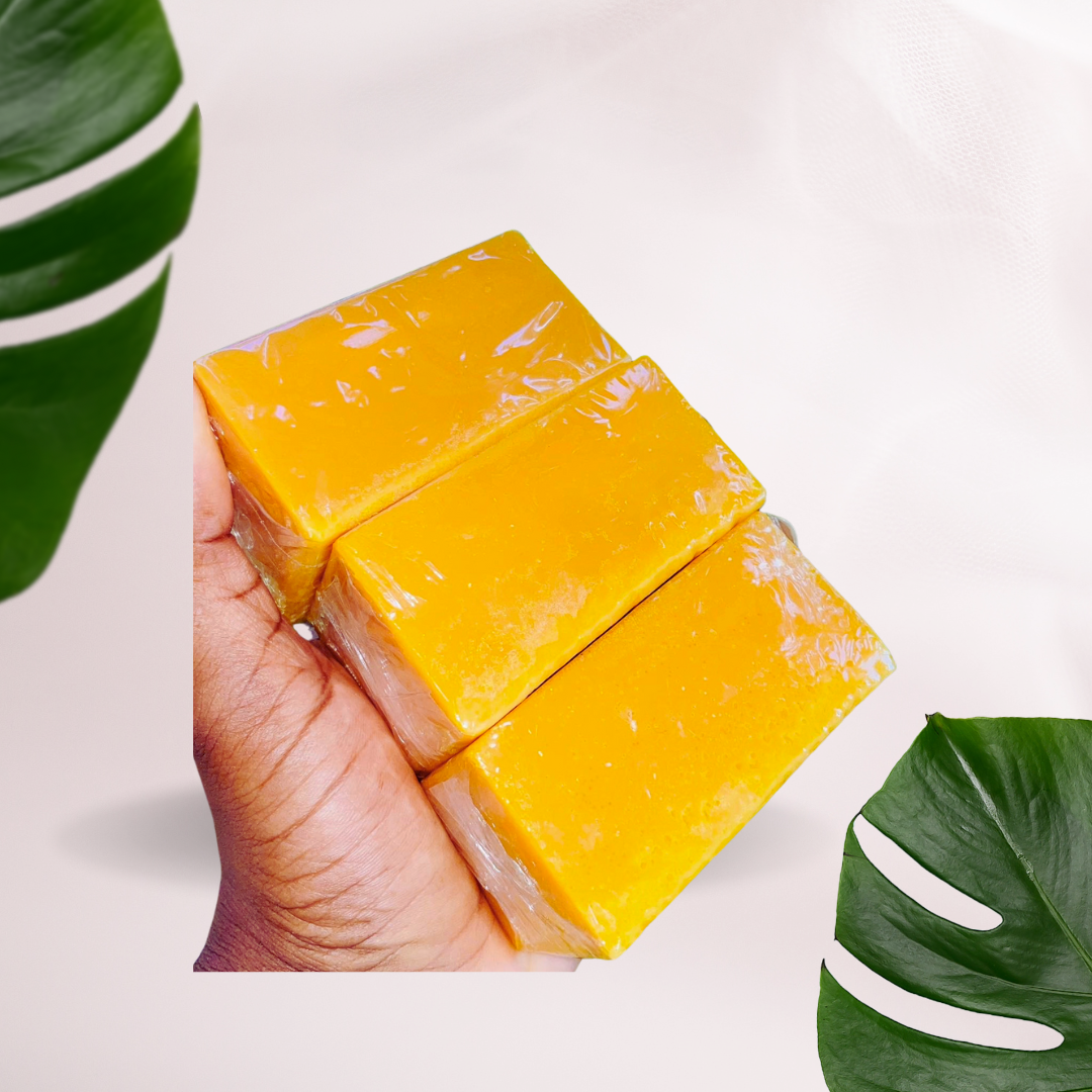 Bright yellow Nouvel Turmeric, Kojic Acid & Ginger Bar Soap with a smooth handcrafted texture, surrounded by turmeric root,