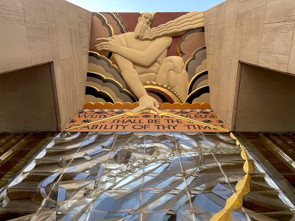 Looking up at beige building that features the artistic piece titled Wisdom located in Rockefeller Center, Midtown, New York City.