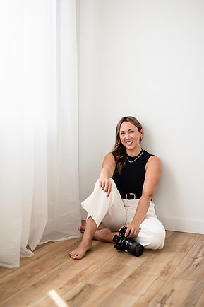Portrait of calgary brand photographer sitting on floor with camera in hand