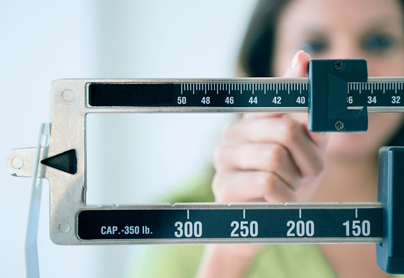 Donna su bilancia controlla i risultati della dieta