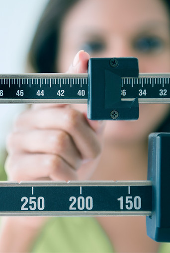 Person, die die Gewichtswaage einstellt