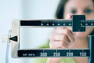 Image of someone adjusting weighing scales.