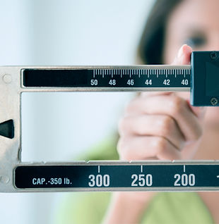 Person adjusting weight scale
