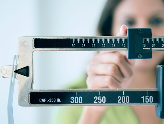 Person adjusting weight scale