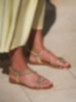 Gold Lunar Brinley sandals on foot with sparkling rhinestone straps and elasticated back strap styled with a pink dress