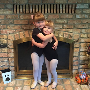 Two child ballet dancers hugging
