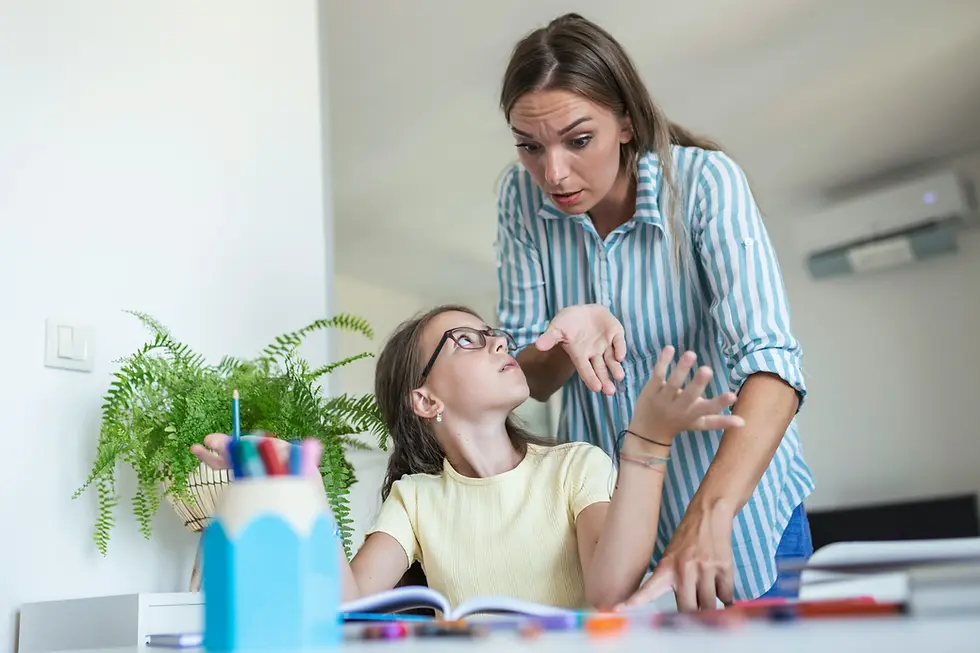 Mom getting upset her daughter sitting at a desk studying with a frustrated expression