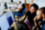 Tutor helping man on laptop