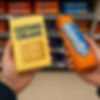 Two hands hold biscuit packs: yellow Custard Creams and orange Hobnobs. Background shows shelves with various biscuit packs.