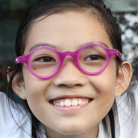 An asian girl smiles whilst wearing prize-winning pink ChildViSion spectacles. For more info click here