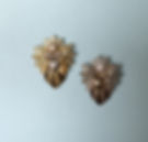 Two decorative angel-shaped brooches, one in gold and the other in silver, with pearl heads and a heart shaped bow.