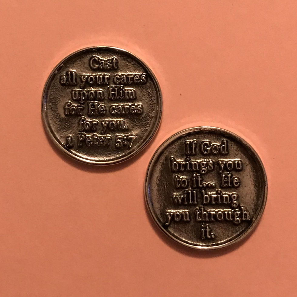 The front of a silver, circular coin with a bible verse engraved on it.