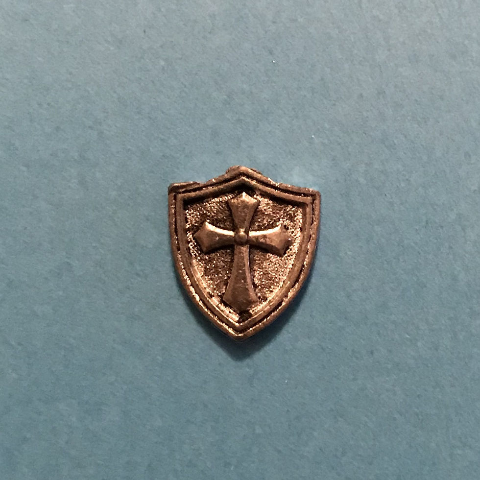 A silver shield charm with a cross on it.