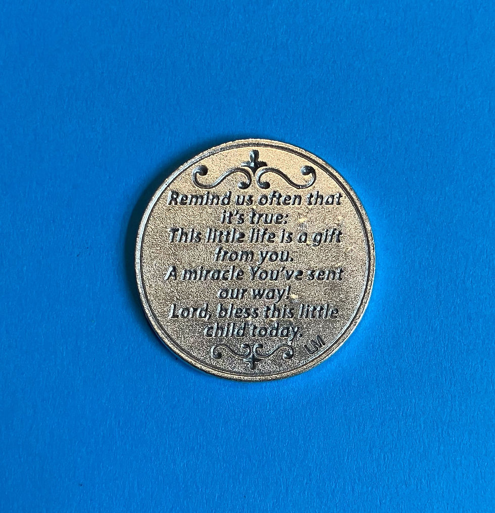 Thumbnail: The front of a round silver coin with engraved prayers on a blue surface. Ornate designs above and below text.
