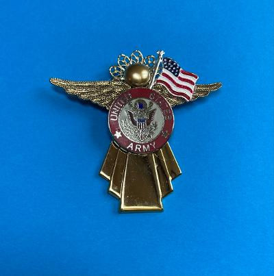 US Air Force emblem badge featuring a gold finish and military-style wings with an American flag. Size: 2 1/4" x 2".