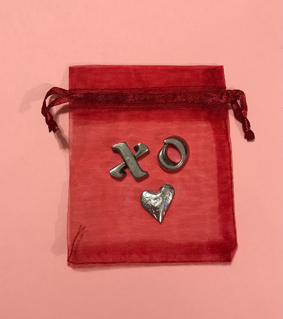 A red organza bag, a silver heart, "X" and an "O"