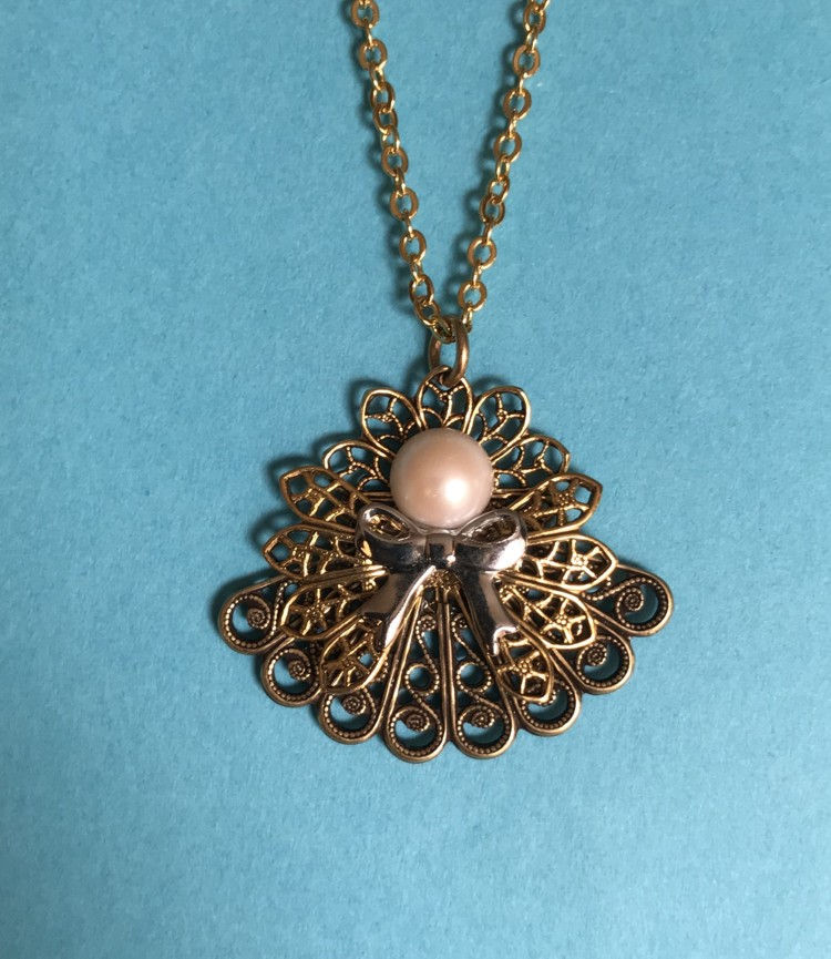 Thumbnail: A gold necklace featuring an elegant angel pendant adorned with a pearl and sparkling birthstones.