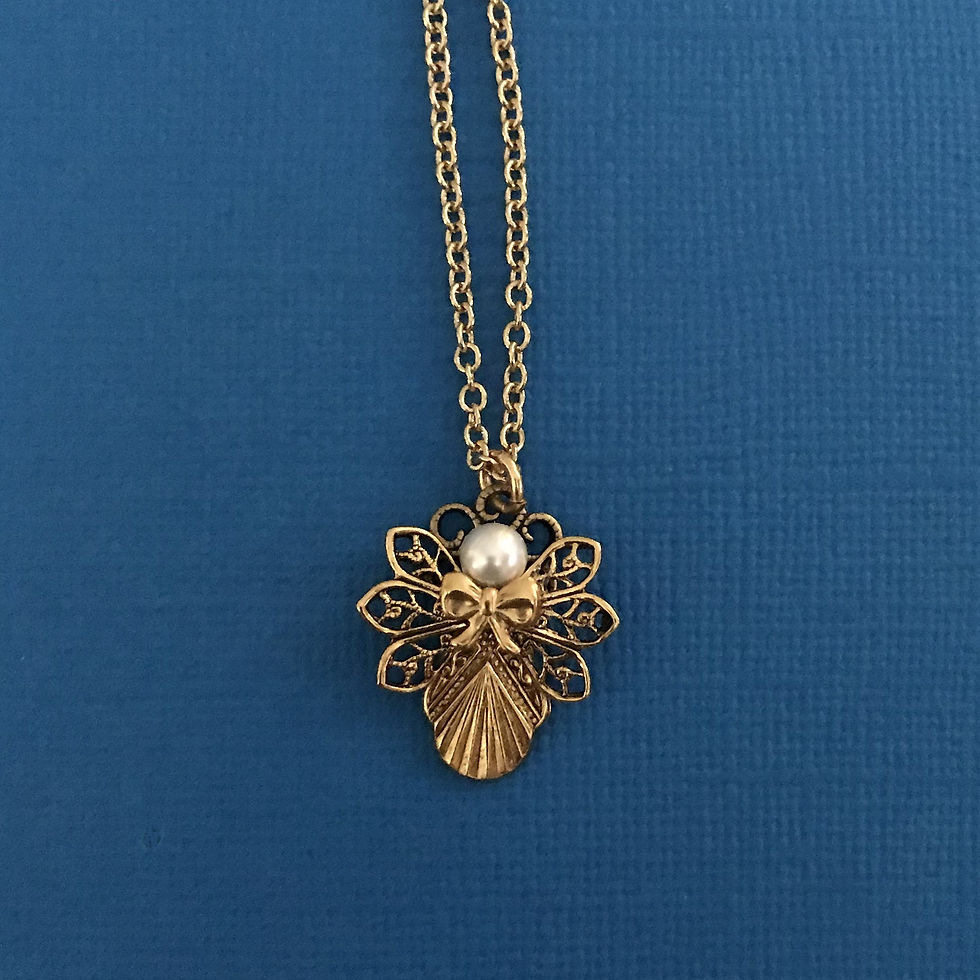 Thumbnail: A decorative gold-toned angel pendant with a pearl head, set against a dark blue background.