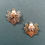 Thumbnail: A close-up of two gold and silver angel pins displayed on a pale green background, highlighting their elegant features.