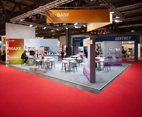 Moderner BASF-Messestand mit klarer Markenpräsenz, Sitzgelegenheiten für Besucher und Infotafeln zu innovativen Produkten wie Circularity und Footwear Solutions.