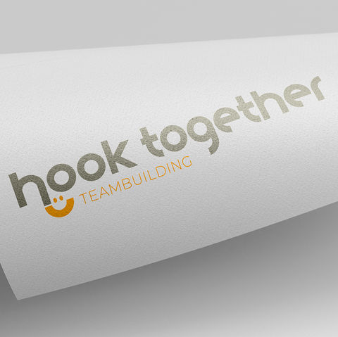 Logo-Design für 'Hook Together Teambuilding', mit freundlicher Typografie und einem lächelnden Smiley-Icon.