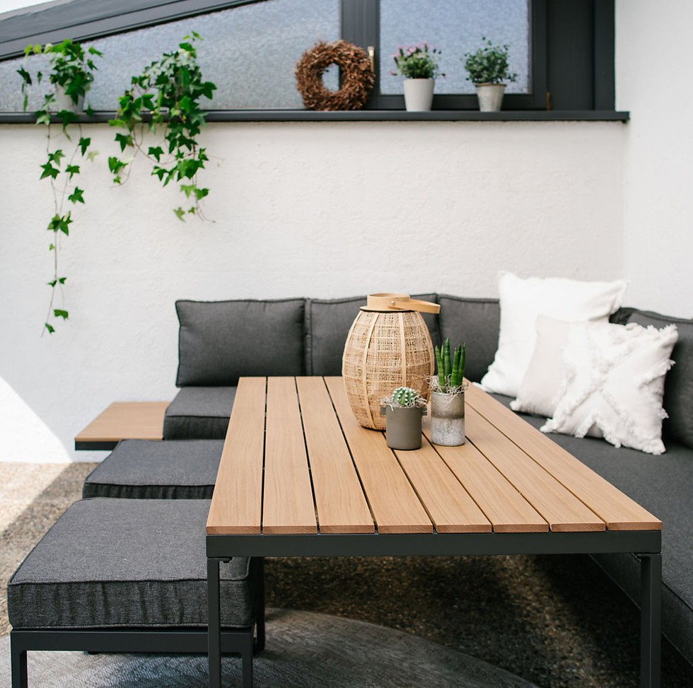 Outdoor Sitzsecke mit Pflanzen, Kissen und Windlicht.