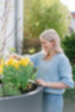 Tanja Lanyi bei der Gestaltung eines dekorativen Blumenkuebels im Außenbereich.