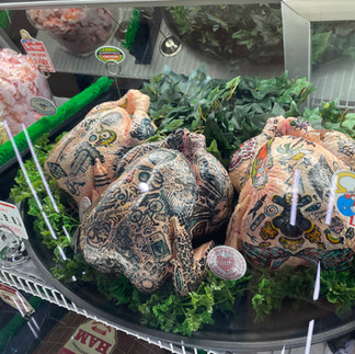 Tattoo'd whole chickens wrapped displayed in the meat case at Omega Mart inside AREA15 Las Vegas.