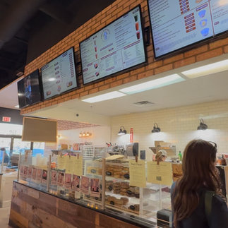 Counter and menu boards inside Abel’s Bagels, with bagels and spreads on display