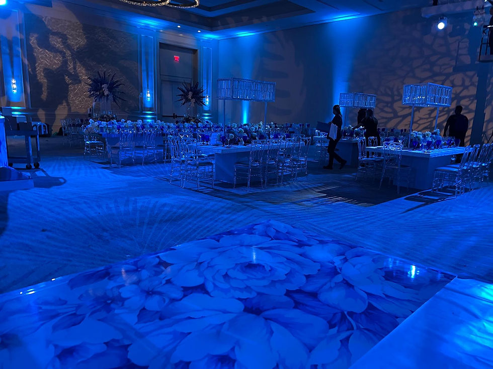 Event ballroom with blue lighting and floral dance floor