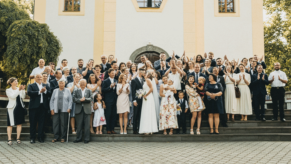 mladomanželský bozk sprevádzaný potleskom svadobných hostí
