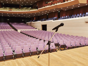 An empty conference stage with a single microphone or lectern.