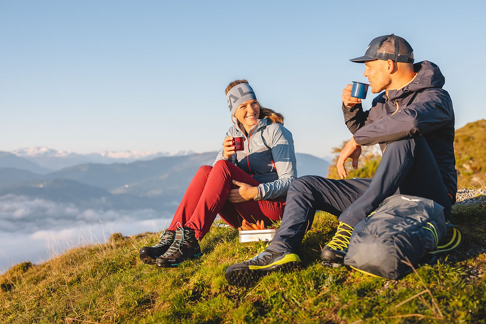 Paar trinkt Tee auf dem Berg mit Blick auf das Tal